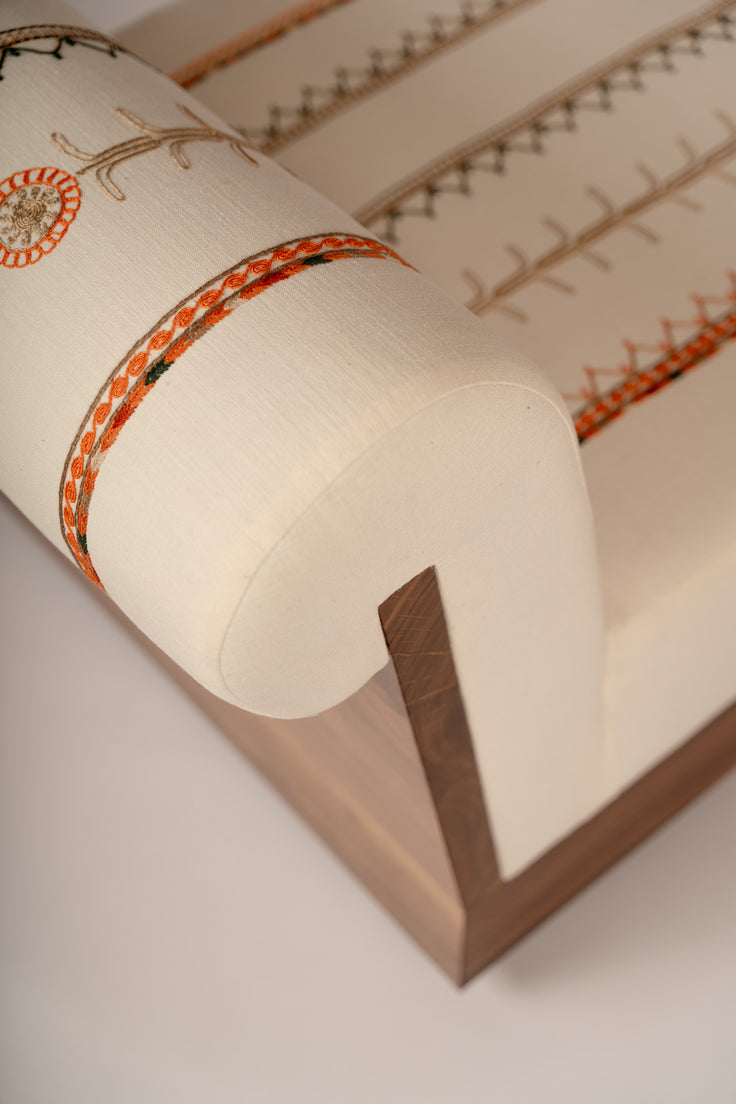Lounge chair with Tahriri embroidery and a solid walnut base