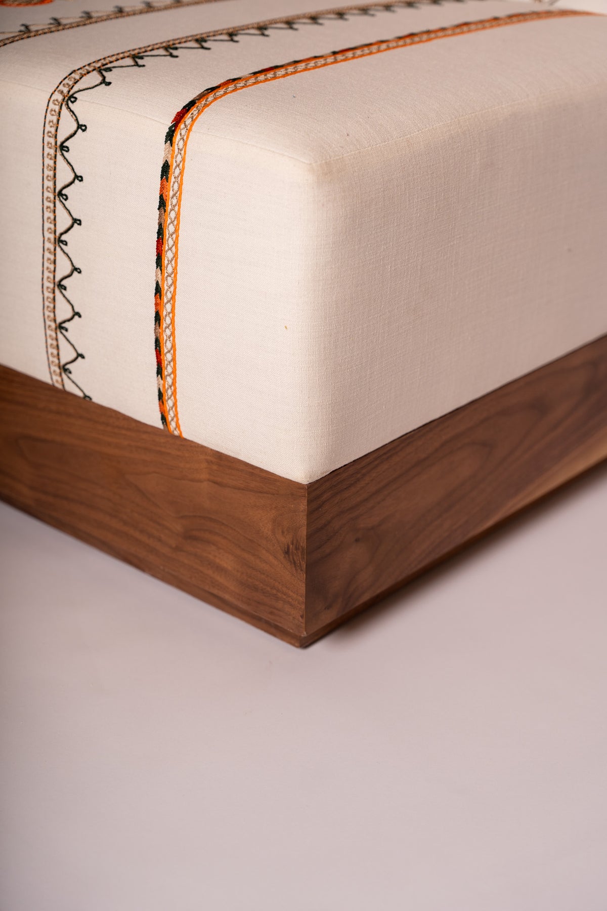 Upholstered bench with Tahriri embroidery and a solid walnut base