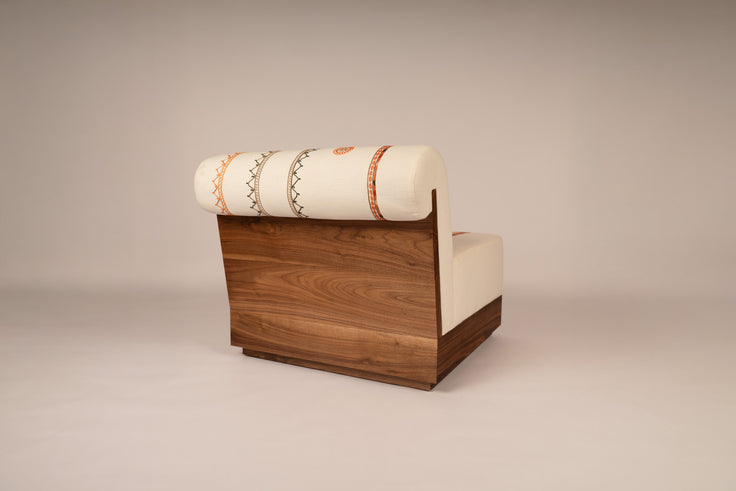 Lounge chair with Tahriri embroidery and a solid walnut base